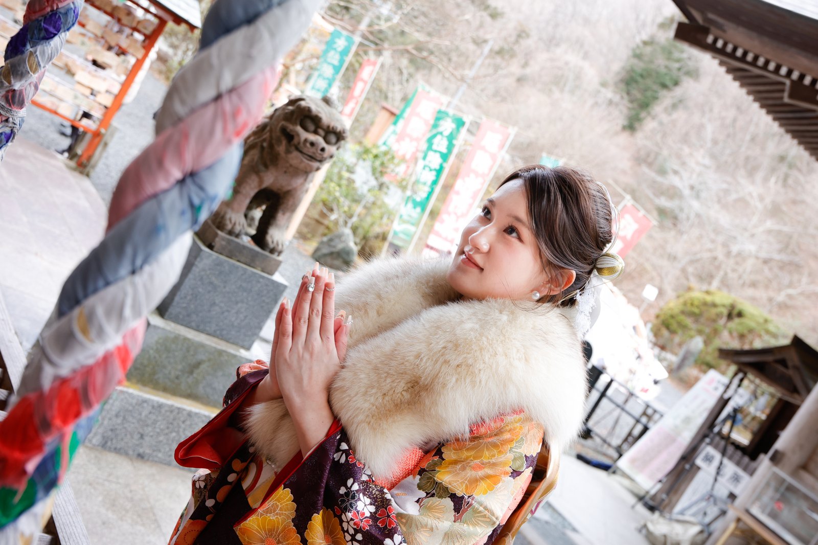 神社前で合掌する振袖姿